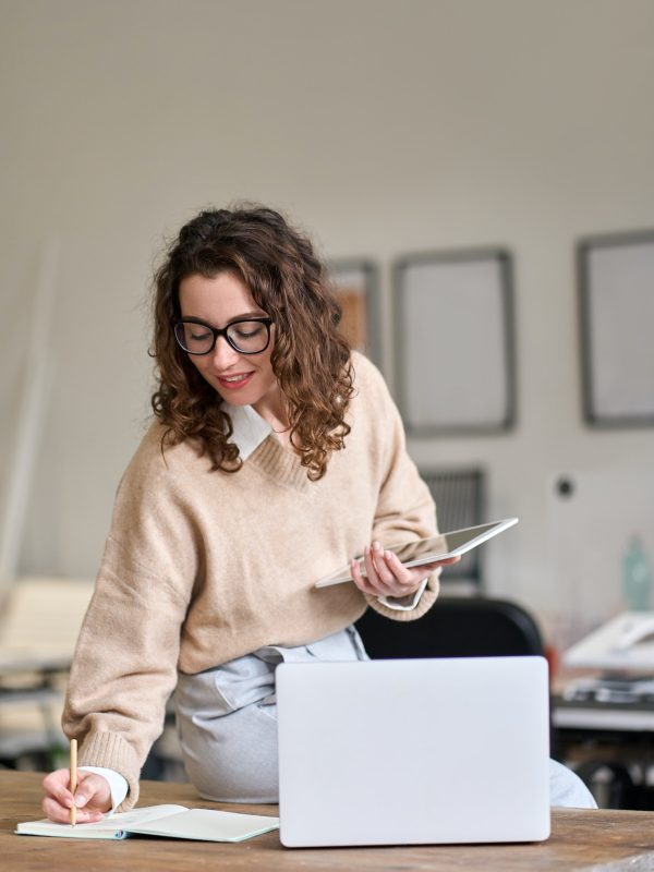 young-smiling-business-woman-working-in-office-using-digital-tablet-vertical.jpg