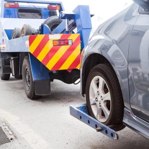 tow-truck-towing-a-broken-down-car-on-the-street-PE9HH3A.jpg